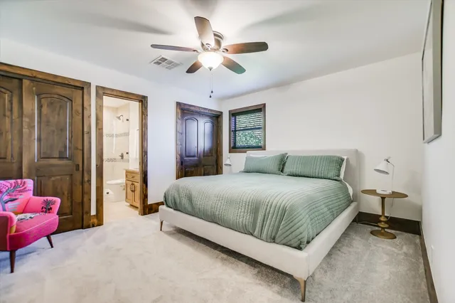 a spacious bedroom with a bed and ceiling fan