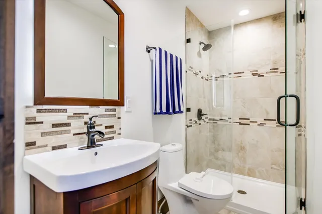 a bathroom with a sink a toilet and shower