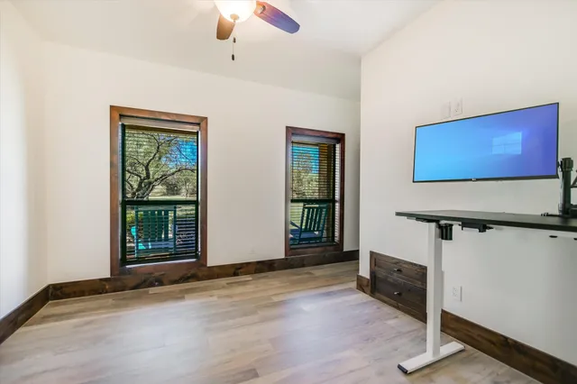 a view of an empty room with window stairs and a chandelier fan