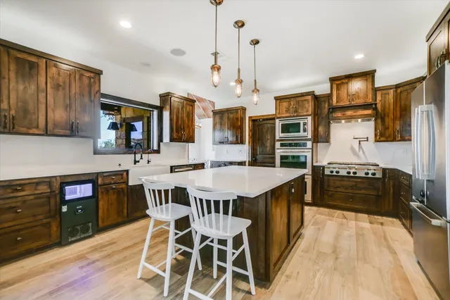 a kitchen with stainless steel appliances granite countertop a kitchen island hardwood floor sink stove and granite counter top
