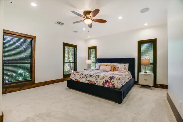 a bed sitting in a spacious bedroom next to a window