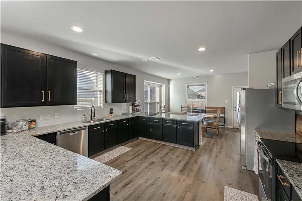 a kitchen with stainless steel appliances granite countertop a sink stove and refrigerator