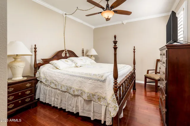 a bedroom with a bed wooden floor and flat screen tv