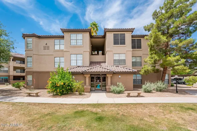 a front view of a building with a garden and plants