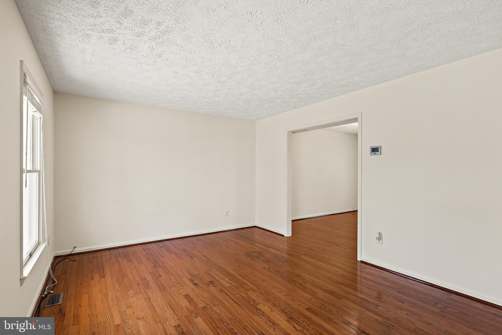 3 Greenknoll Boulevard Hanover, MD 21076 - Photo 4 of 34 a view of an empty room with wooden floor and a window