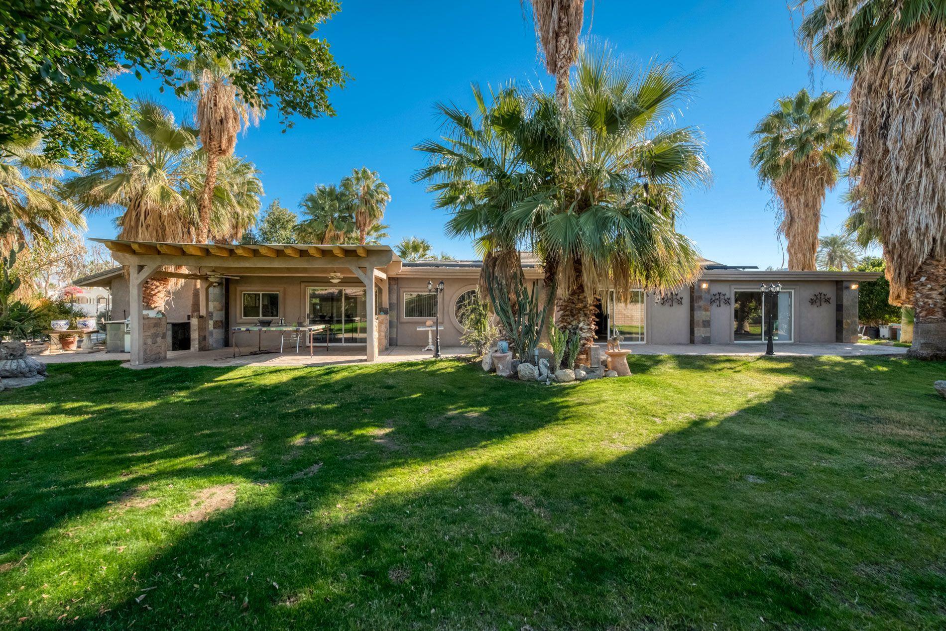 72411 Rancho Road Rancho Mirage, CA 92270 - Photo 22 of 25 a front view of a house with a garden