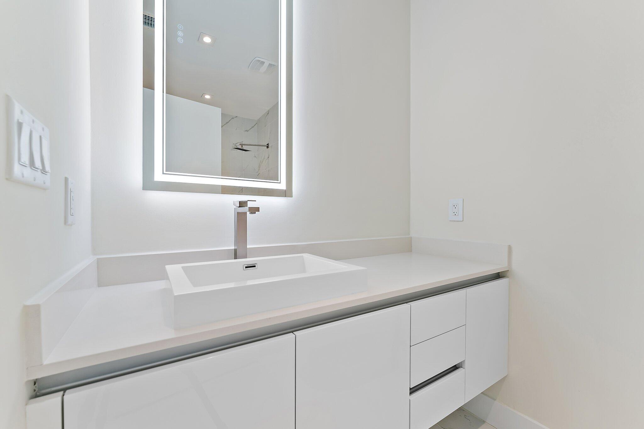 3100 North Ocean Drive, Unit H1206 Singer Island, FL 33404 - Photo 30 of 78 a bathroom with a sink and a mirror