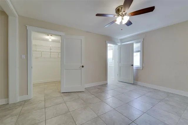 an empty room with chandelier fan