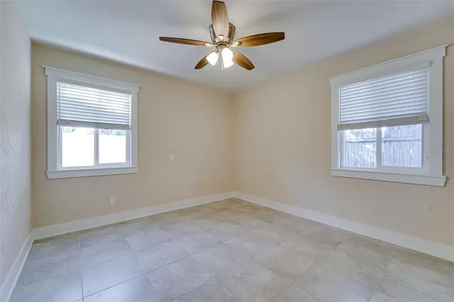 a view of a livingroom with a chandelier fan and windows
