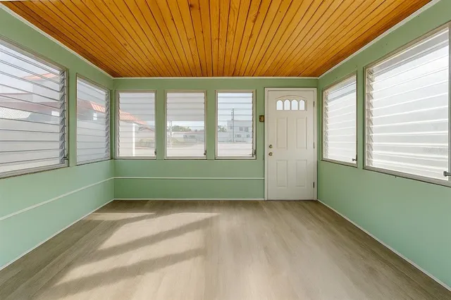a view of an empty room with a window and a ceiling fan