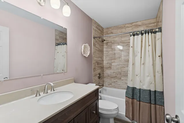 a bathroom with a sink a toilet a mirror and shower