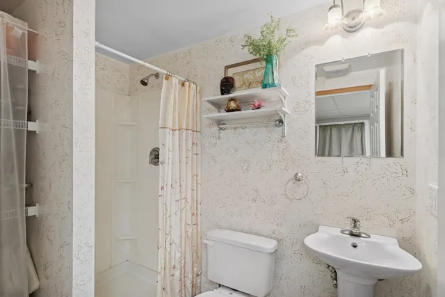 a bathroom with a sink a toilet and shower