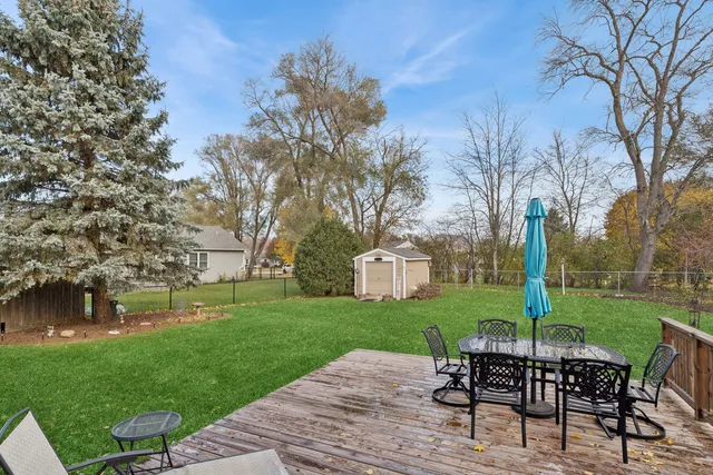 a view of a wooden deck with chairs and a yard