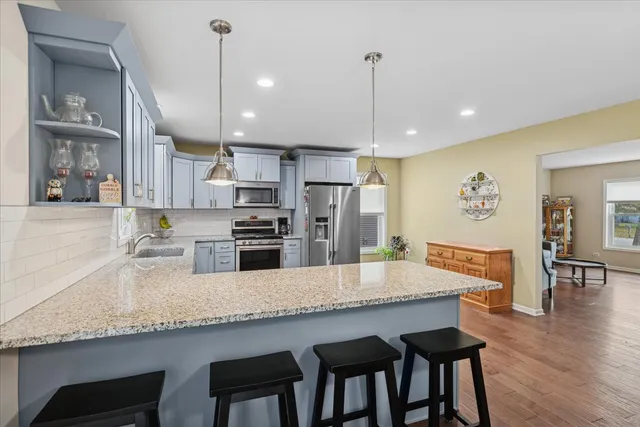 a kitchen with granite countertop kitchen island a table and chairs in it