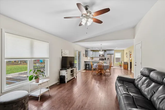 a living room with furniture and a flat screen tv with wooden floor