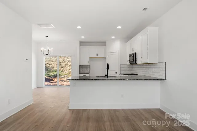 a large kitchen with stainless steel appliances granite countertop a stove a sink and a refrigerator