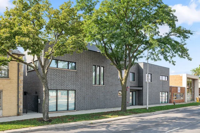 a front view of a house with a tree