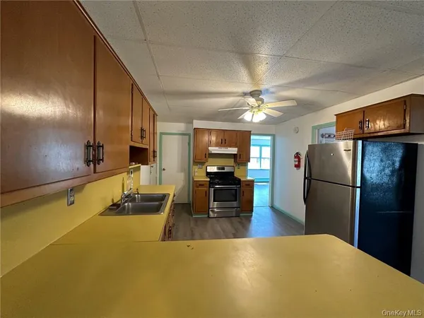 a kitchen with stainless steel appliances granite countertop a sink refrigerator and cabinets