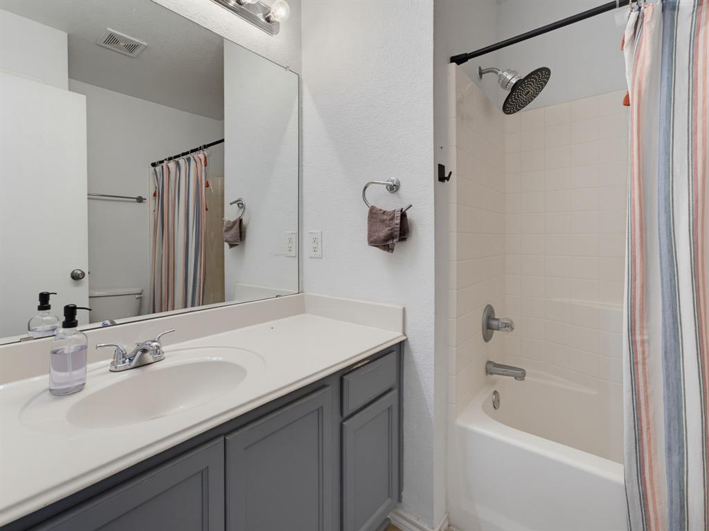 600 Stirling Road Rhome, TX 76078 - Photo 27 of 38 Bathroom featuring a single vanity with a light-toned countertop, gray shaker-style cabinetry, an integrated sink basin, a chrome faucet, and a large wall-mounted mirror