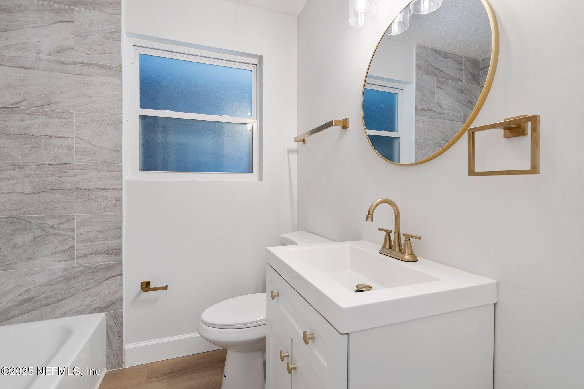 7420 Sandhurst Road South Jacksonville, FL 32277 - Photo 10 of 35 a bathroom with a sink toilet and mirror