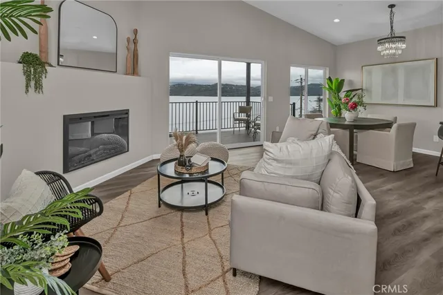 a living room with furniture a chandelier and kitchen view