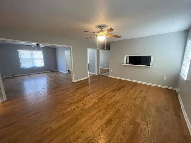 a view of empty room with wooden floor