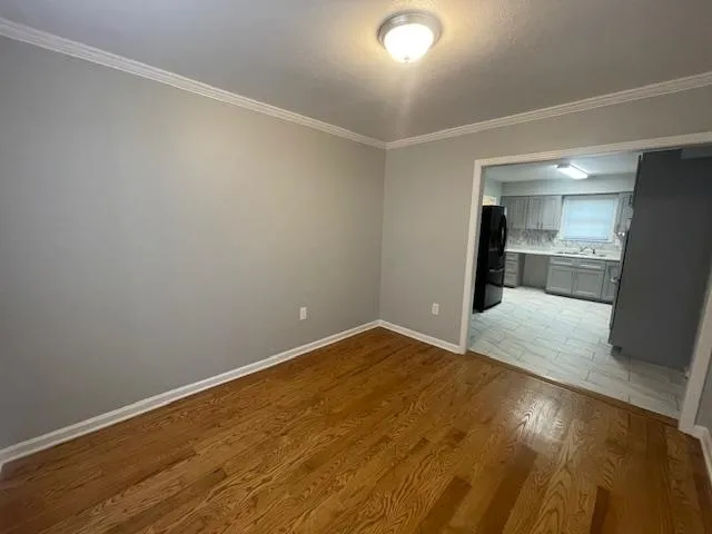 an empty room with wooden floor and natural light