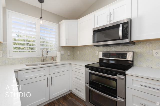 704 West Vahe Street Draper, UT 84020 - Photo 10 of 35 Modern kitchen featuring white shaker cabinetry, stainless steel appliances, light-toned countertops, decorative backsplash tiling, and wood-finish flooring