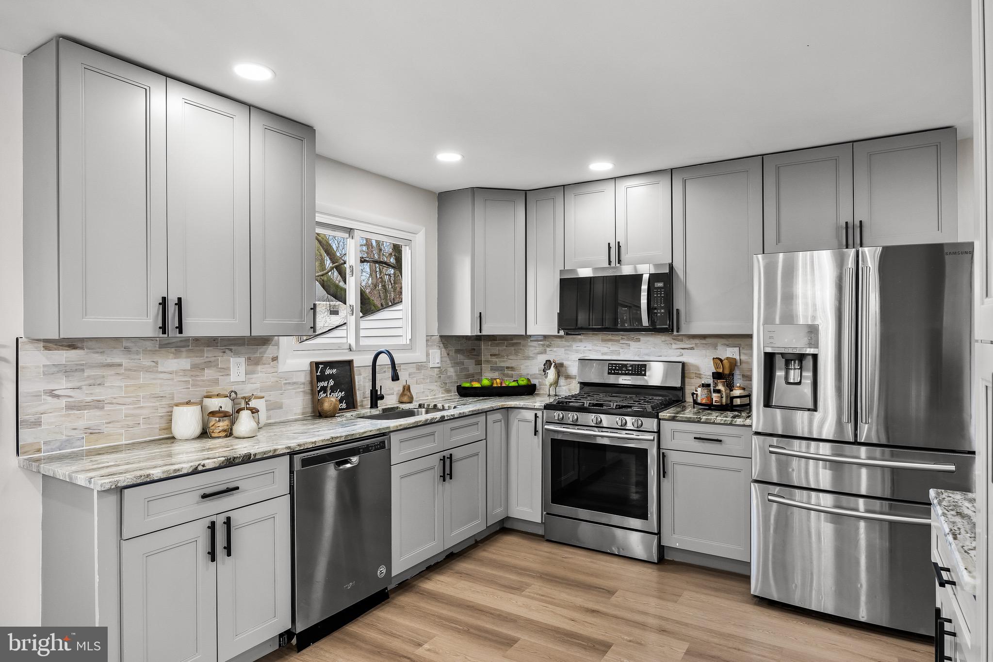 301 Cardinal Road Beverly, NJ 08010 - Photo 11 of 27 a kitchen with kitchen island granite countertop stainless steel appliances and wooden cabinets
