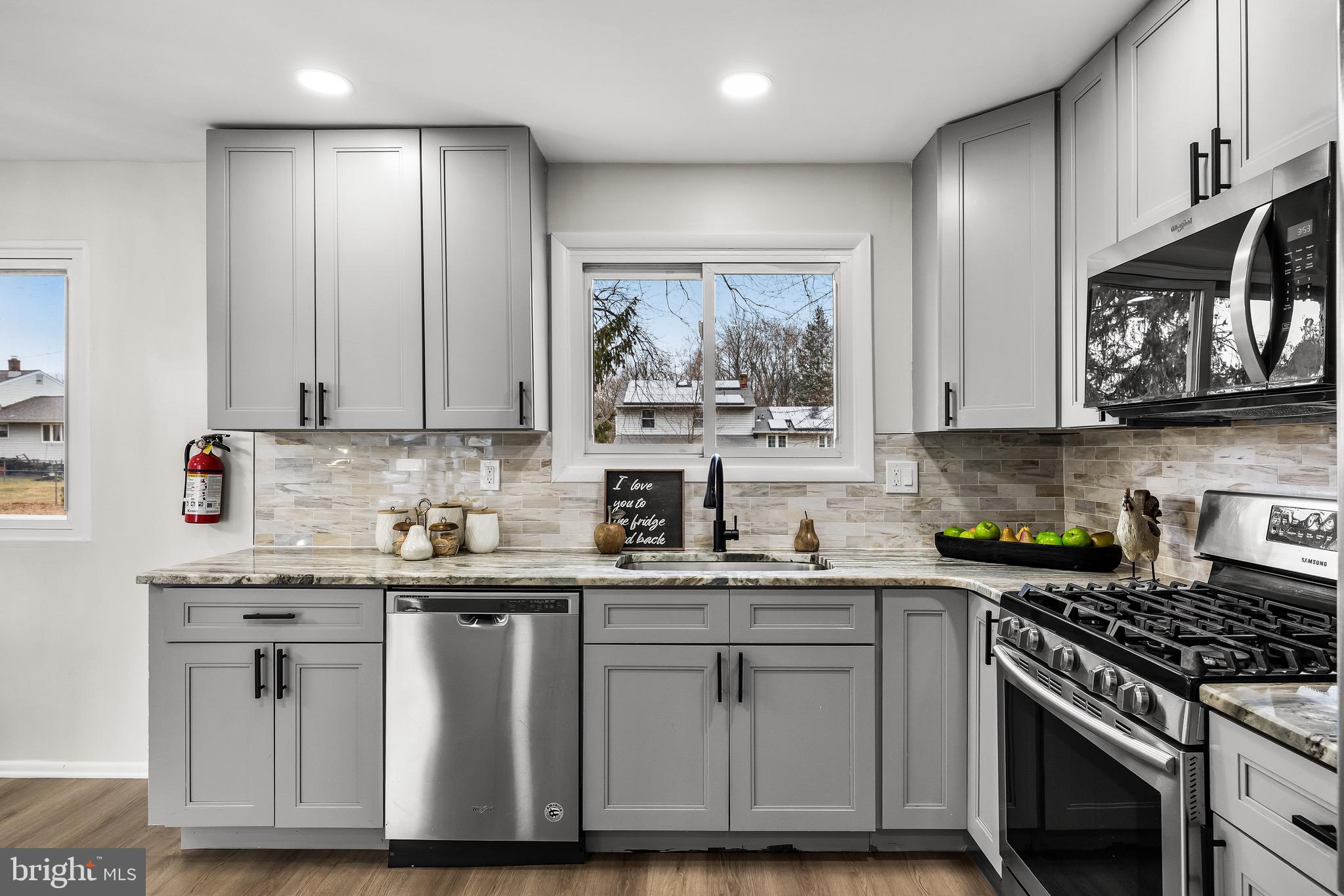 301 Cardinal Road Beverly, NJ 08010 - Photo 12 of 27 a kitchen with stainless steel appliances granite countertop a stove a sink and a microwave