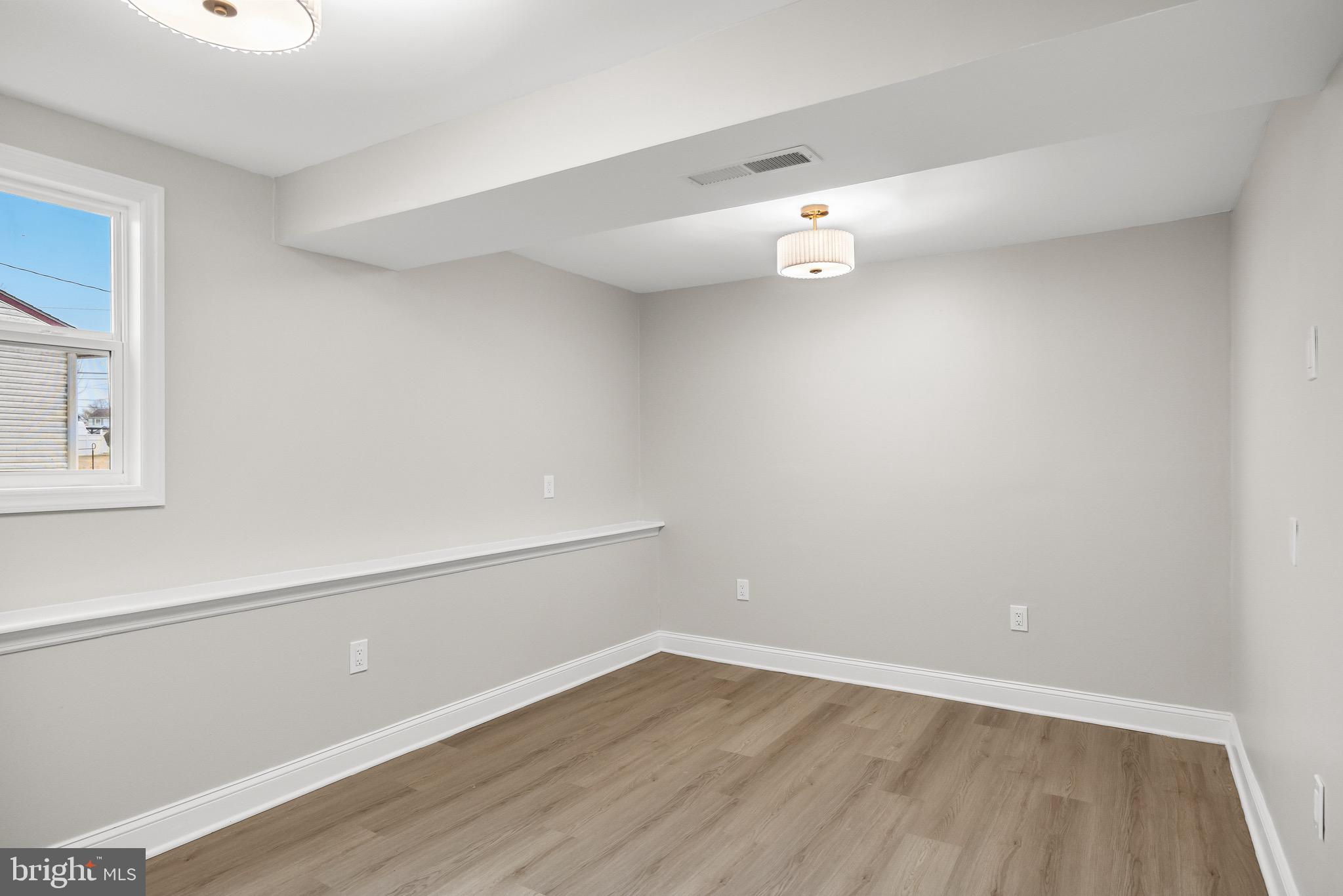 301 Cardinal Road Beverly, NJ 08010 - Photo 23 of 27 a view of an empty room with wooden floor and a window