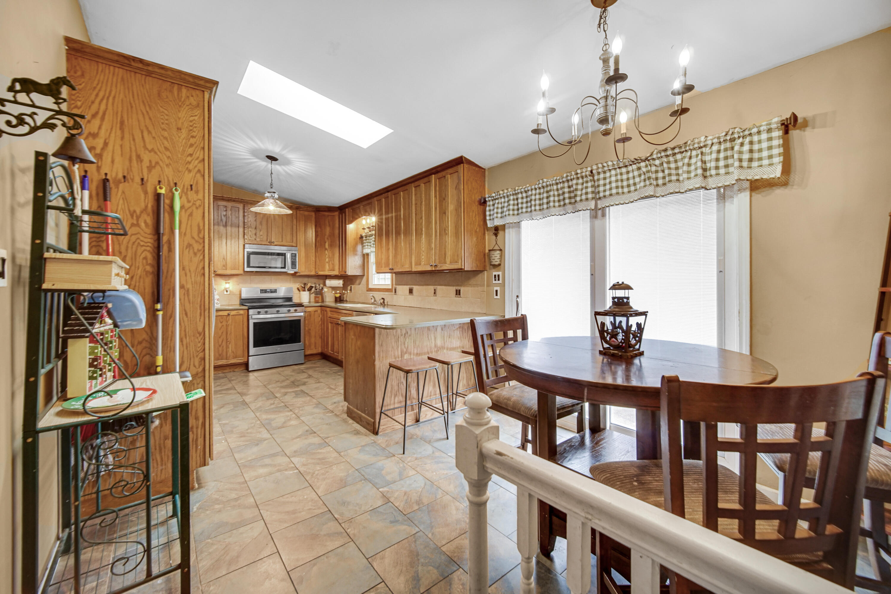 4038 Kingsway Drive Crown Point, IN 46307 - Photo 7 of 18 a kitchen with stainless steel appliances kitchen island granite countertop a refrigerator a stove a sink dishwasher and a dining table with wooden floor