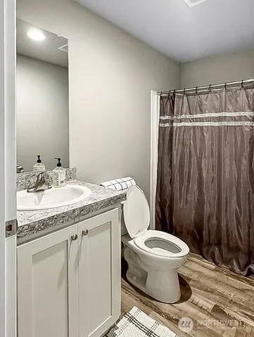 a bathroom with a granite countertop sink toilet and a mirror
