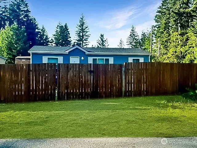 a view of a backyard with potted plants and wooden fence