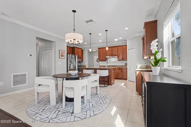a living room with dining table and a chandelier