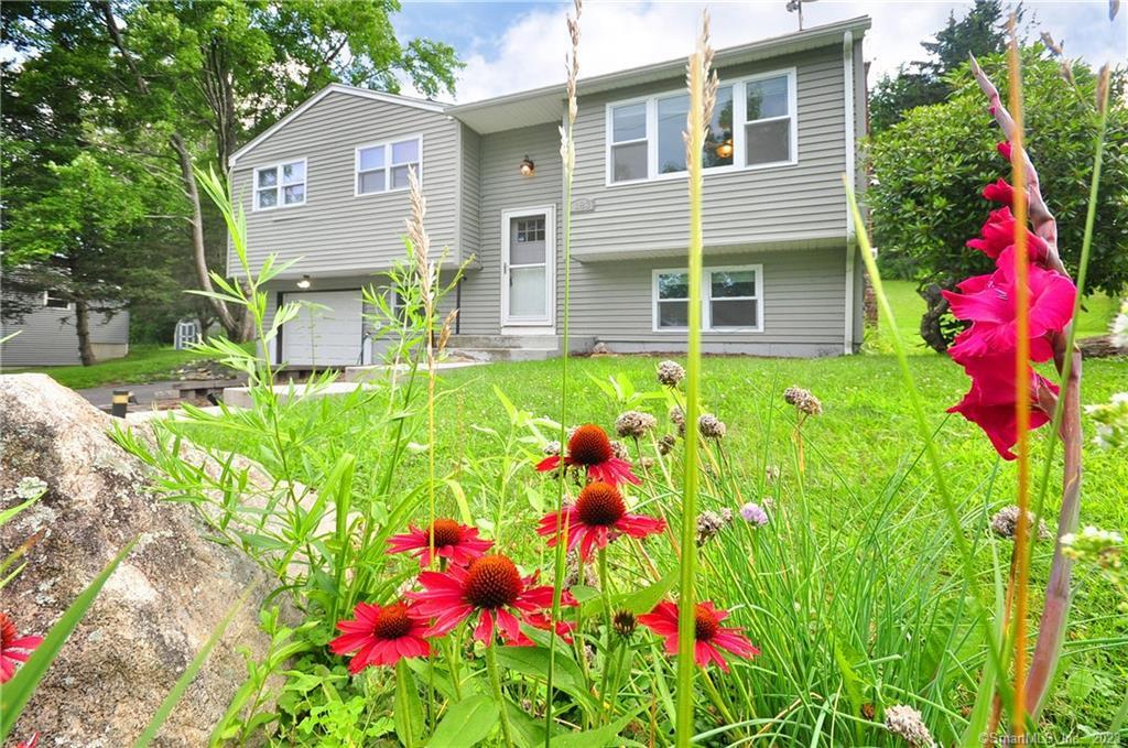 a front view of a house with a yard and fountain
