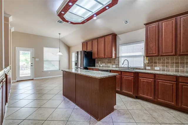 a kitchen with stainless steel appliances granite countertop a stove a sink dishwasher and a refrigerator
