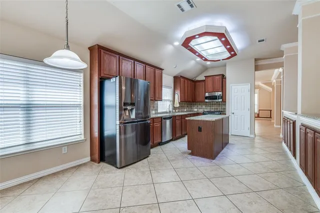 a kitchen with stainless steel appliances granite countertop a refrigerator and a sink
