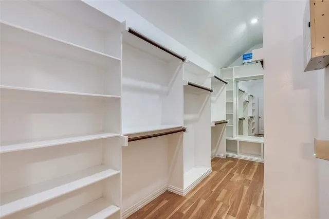 a view of walk in closet with empty racks