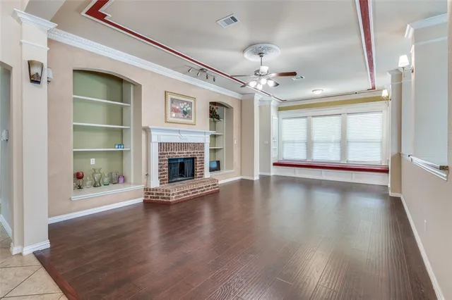 wooden floor fireplace and windows in an empty room
