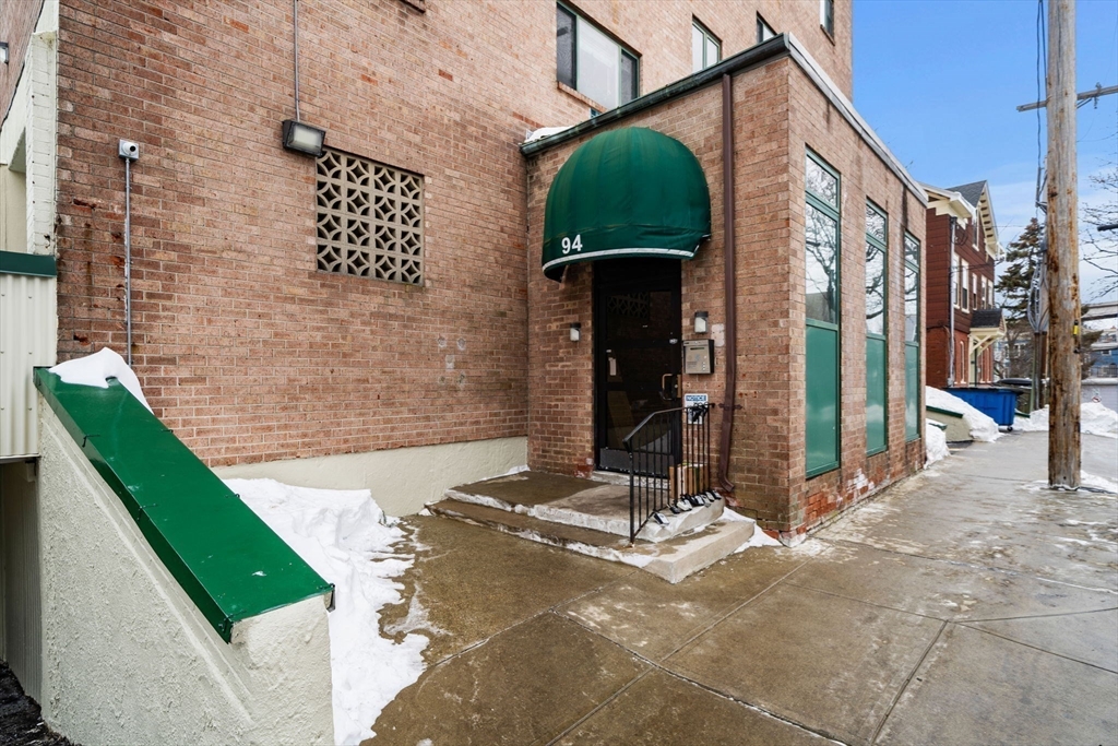 94 Beacon Street, Unit 83 Somerville, MA 02143 - Photo 22 of 22 a backyard of a building with barbeque oven and glass windows