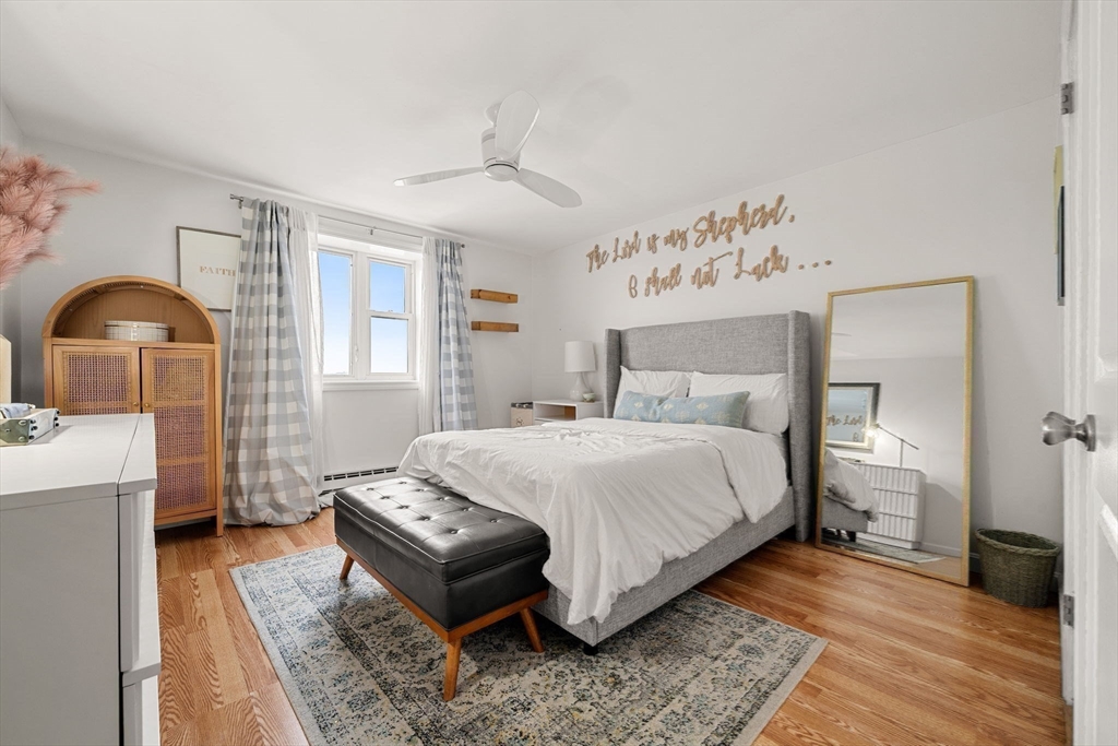 94 Beacon Street, Unit 83 Somerville, MA 02143 - Photo 9 of 22 a bedroom with a bed and a chandelier