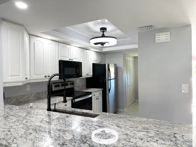 a view of a refrigerator in kitchen and a sink