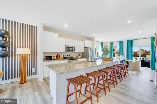 a large kitchen with sink a refrigerator and wooden floor
