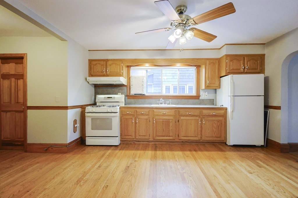 580 2nd Street Everett, MA 02149 - Photo 11 of 29 a kitchen with a refrigerator a stove cabinets and wooden floor