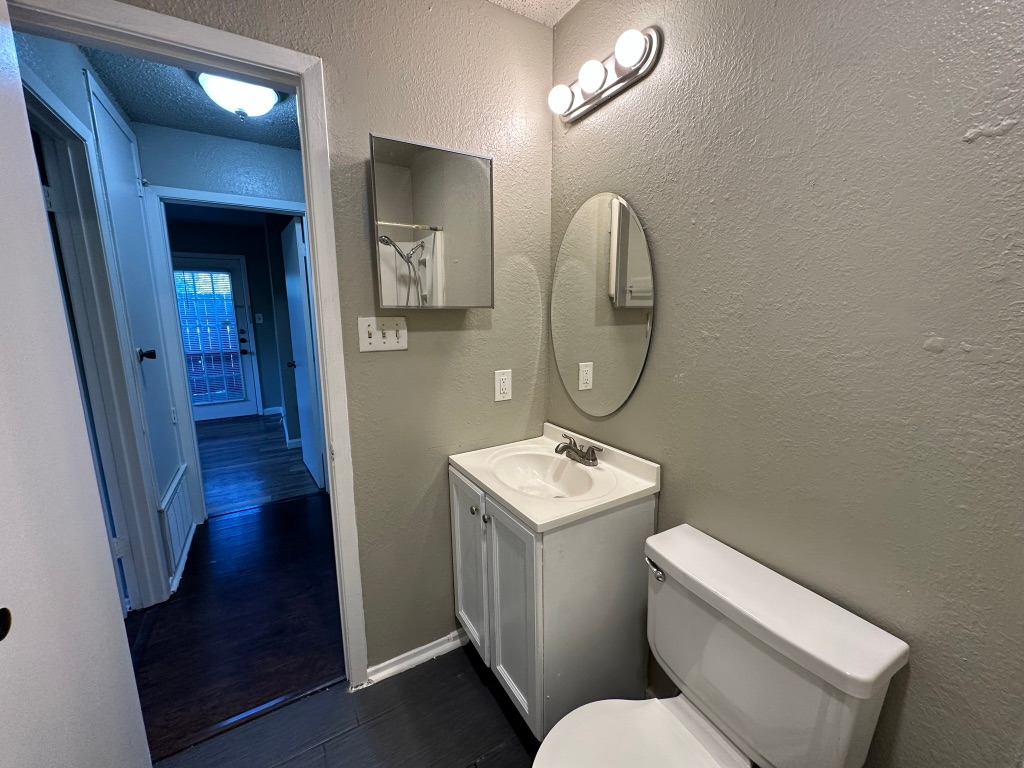 903 Taulbee Lane, Unit B Austin, TX 78757 - Photo 18 of 20 a bathroom with a toilet a sink and a mirror