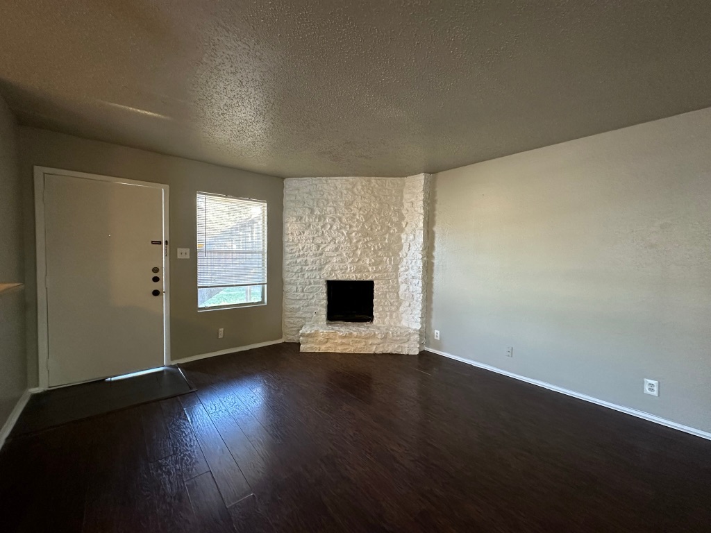 903 Taulbee Lane, Unit B Austin, TX 78757 - Photo 4 of 20 an empty room with wooden floor and a fireplace