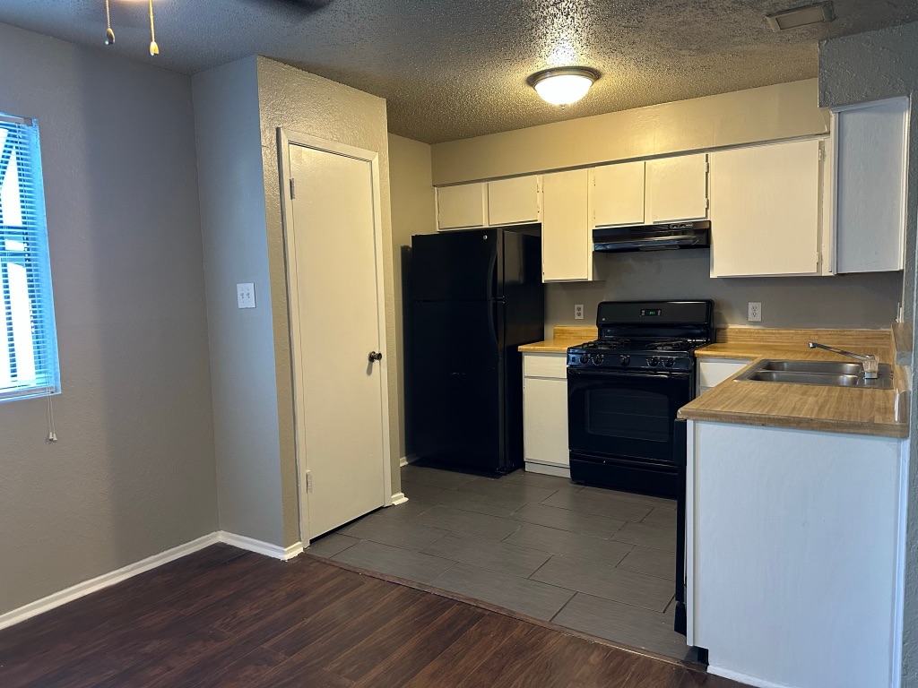 903 Taulbee Lane, Unit B Austin, TX 78757 - Photo 7 of 20 a kitchen with stainless steel appliances granite countertop a refrigerator and a stove top oven