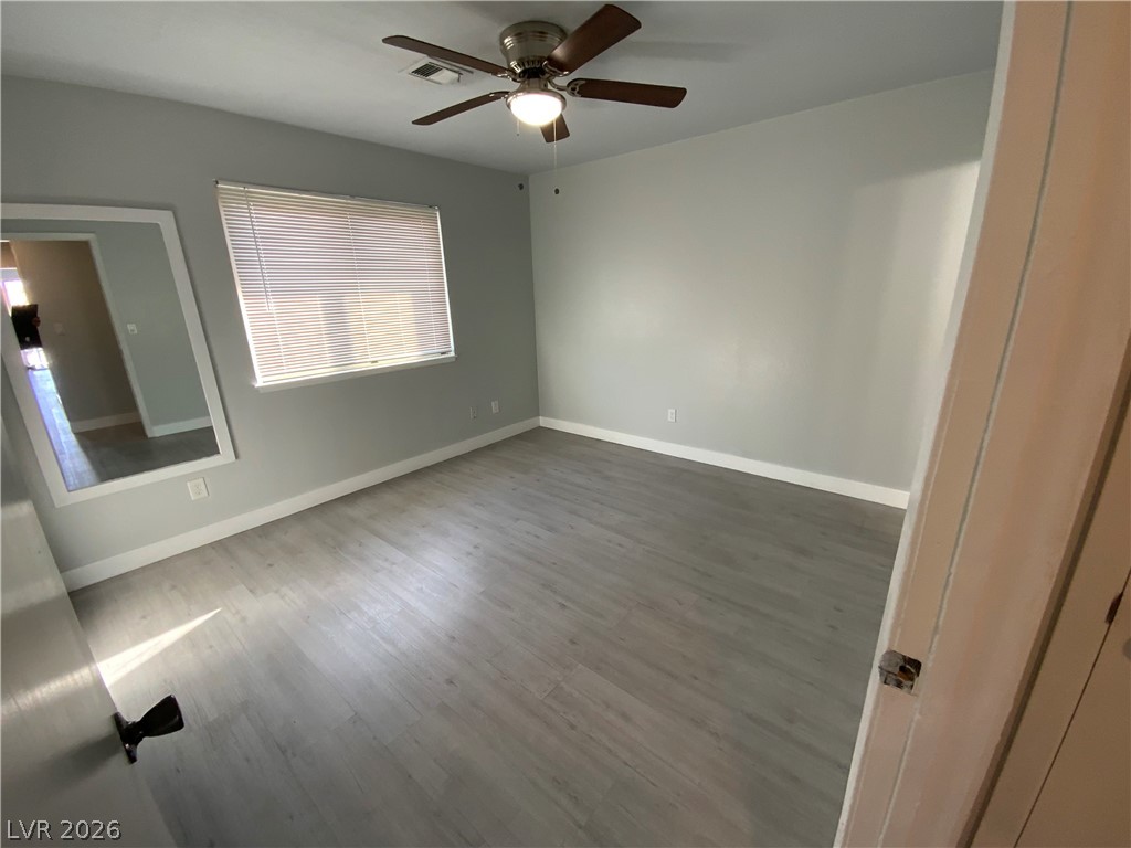 466 East Sunset Road, Unit C Henderson, NV 89011 - Photo 10 of 12 Unfurnished bedroom featuring a ceiling fan, wood finished floors, visible vents, and baseboards