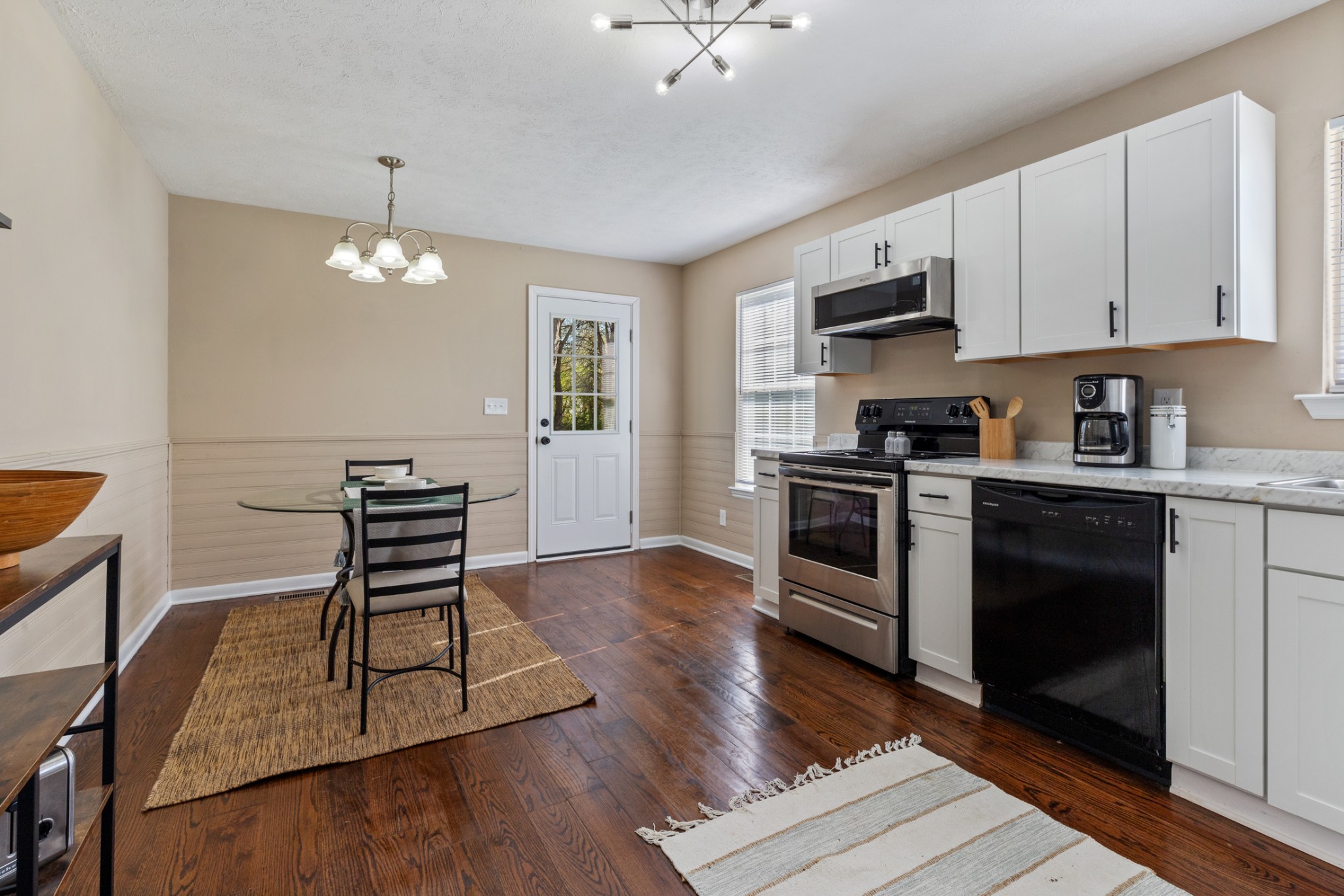 108 Aaron Drive Burns, TN 37029 - Photo 11 of 31 a kitchen with stainless steel appliances a stove a sink dishwasher a microwave oven and a dining table with wooden floor